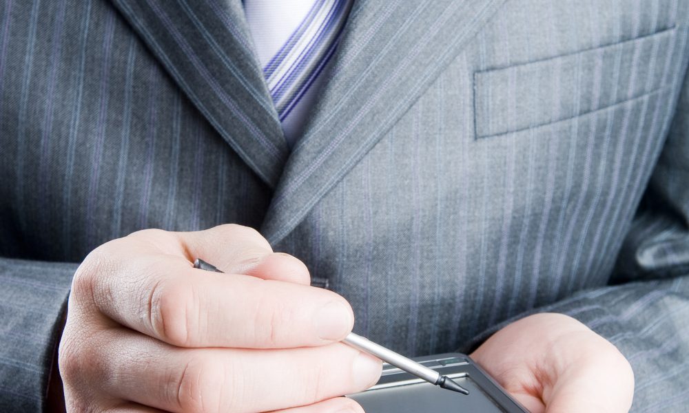 Close-up of a businessman holding pocket PC, focus on hand